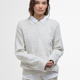 Woman wears the Barbour Edda Knitted Jumper with multicolour flecks throughout the light coloured material.