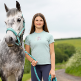 Rider leads a grey pony wearing the LeMieux Young Riders Arianna T-Shirt in aqua