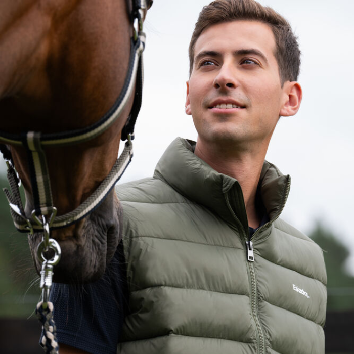 Male rider wears the Eskadron Mens Classic Sports Quilt Waistcoat in Dusty Olive