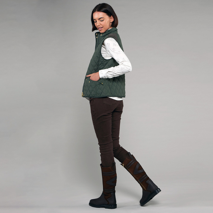 Woman styles the Toggi Ladies Storford Quilted Gilet in Dark Khaki with a white patterned country shirt