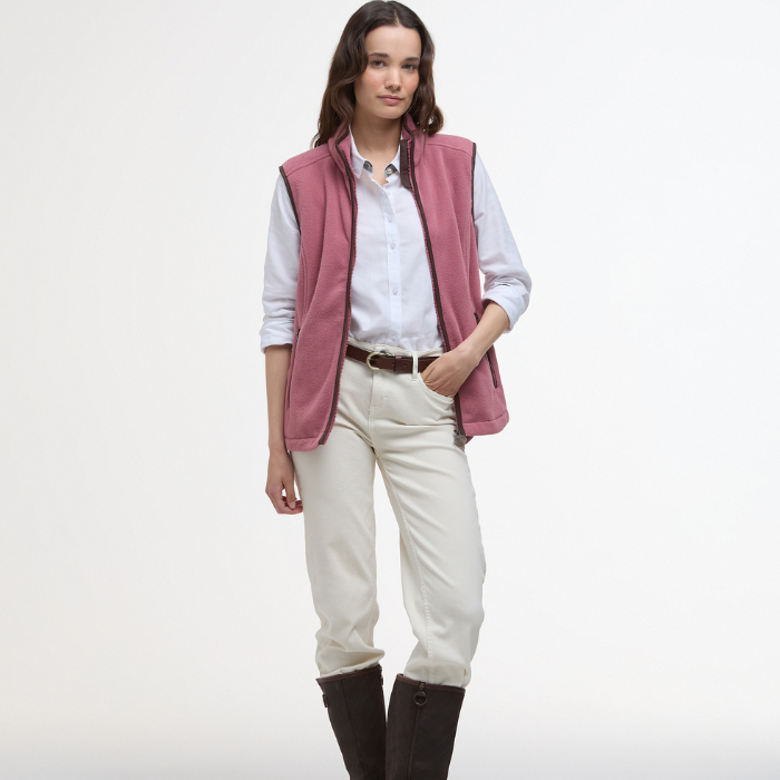 Female styles the Ladies Country Colton Fleece Gilet in Deep Pruce with a crisp white shirt, cream jeans and long boots.