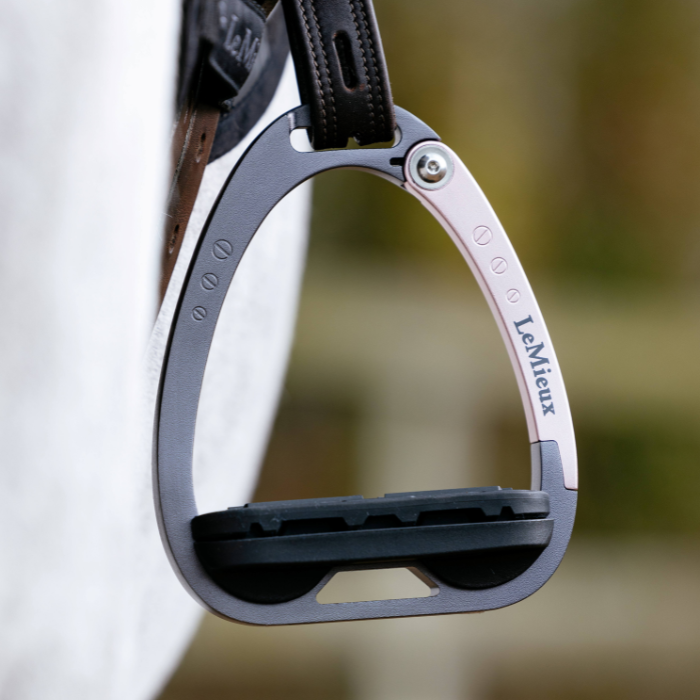 LeMieux Junior Vector Balance Stirrups in rose gold hanging from a stirrup leather