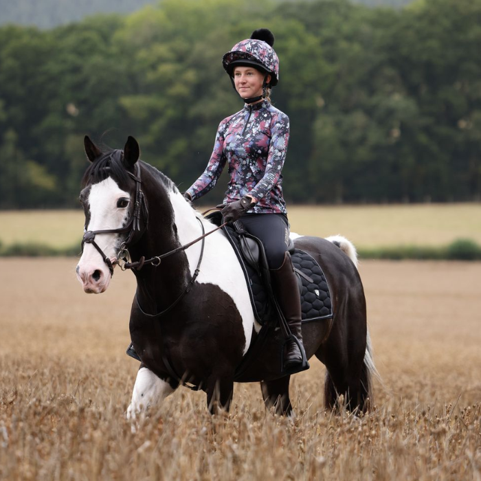 Girl On Horse Wears the Aubrion React Young Rider Long Sleeve Base Layer in Abstract | Eland Lodge