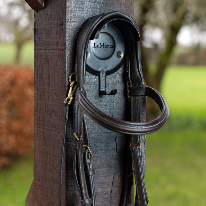 Black LeMieux Bridle Bracket fixed to a post with a bridle hanging