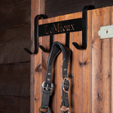 The LeMieux Headcollar Hanger in black hooked over a stable door with a headcollar hanging from one of the rails