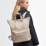 Female wears the Barbour Olivia Backpack in Light Sand over her shoulder