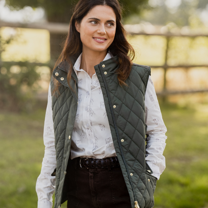 Woman in a field wears the Toggi Ladies Storford Quilted Gilet in Dark Khaki